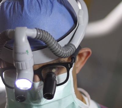 Dr. Vias with surgical lamp and scrubs.