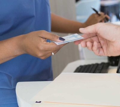 Patient providing ID card at medical office.