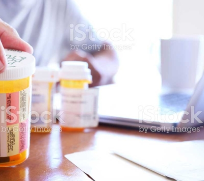 Man taking inventory of prescription drugs to dispose.