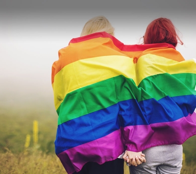 Two same sex couple with rainbow flag 