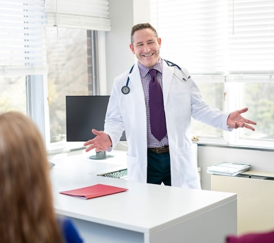 Happy doctor greeting patients