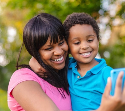 Afro-American mom and son taking selfie photo outdoors