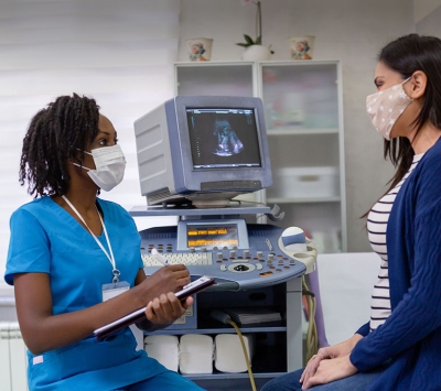 Black nurse consulting female patient