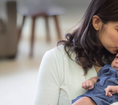 New mom kissing her infant.