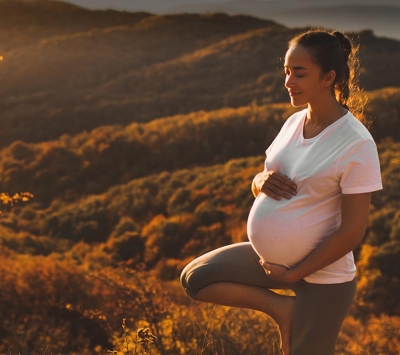 Pregnant woman outdoors practicing yoga