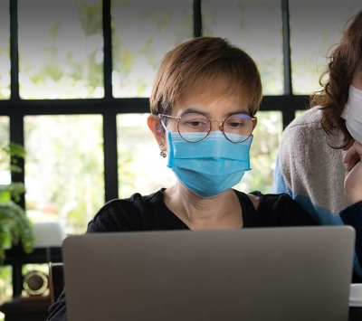 Asian daughter and mother viewing laptop