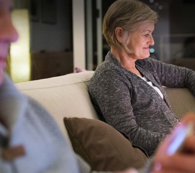 Mature couple reading on devices at home