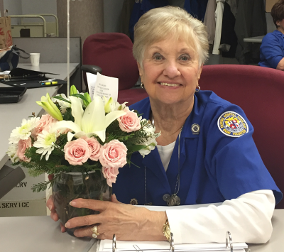 lady at desk holding flowers