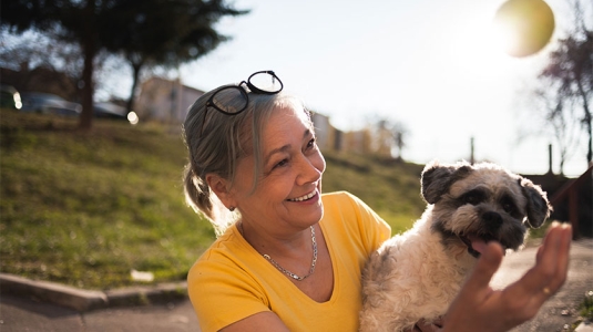 Mature woman playing catch with dog