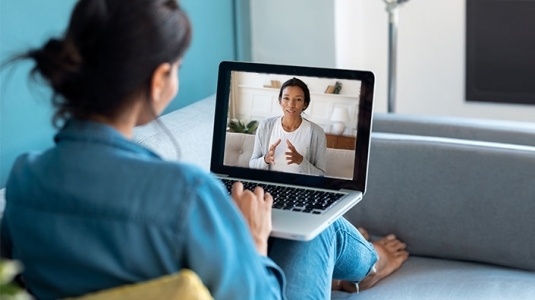 woman at home speaking to doctor on laptop