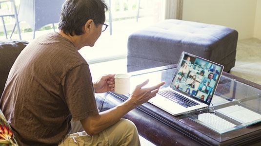 Man participating in group session on laptop.