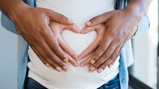 Pregnant mother holding belly.