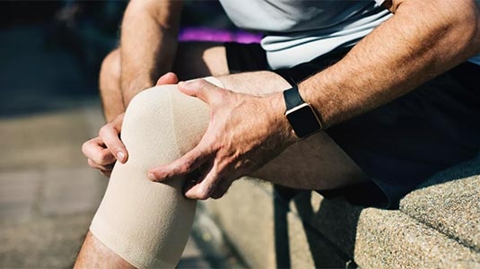 Close up of mature man's knee with support sleeve