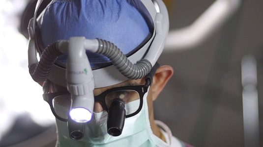 Doctor in scrubs performing neurosurgery