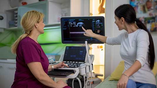 Female patient pointing to diagnostic screen
