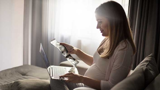 Women on computer looking for birthing centers. 