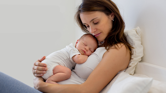 mom cuddling newborn baby