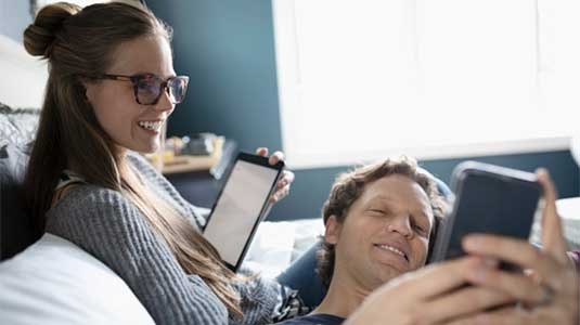 Couple sharing information from digital devices.