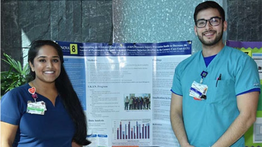 two nurses giving a poster presentation