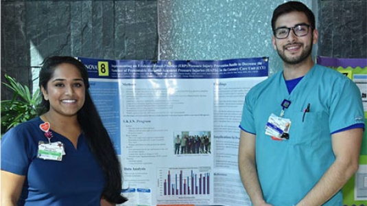 two nurses giving a poster presentation