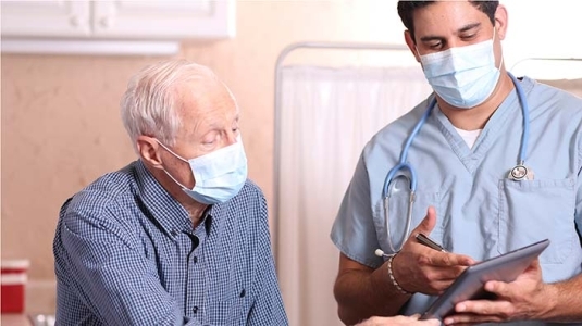 masked patient and doctor having a consult
