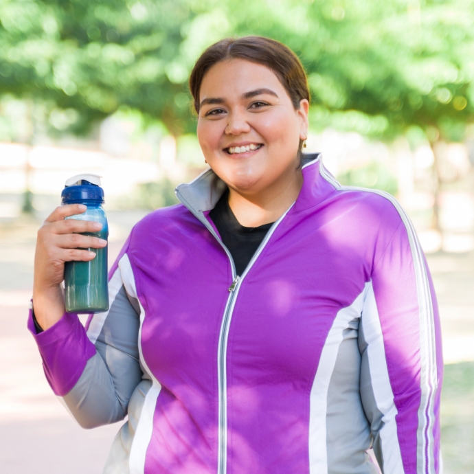 Woman outside wearing workout clothes holding water bottle