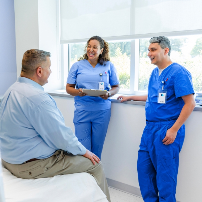 Physicians with patient discussing options in treatment room