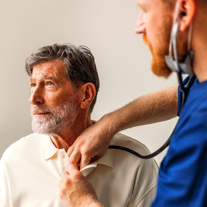 healthcare worker listening to mature man heart
