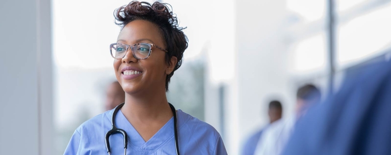 young woman in scrubs looking up hopefully