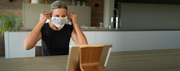 Mature woman making mask at home 