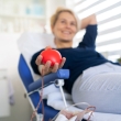 Woman donating blood with heart foam in hand